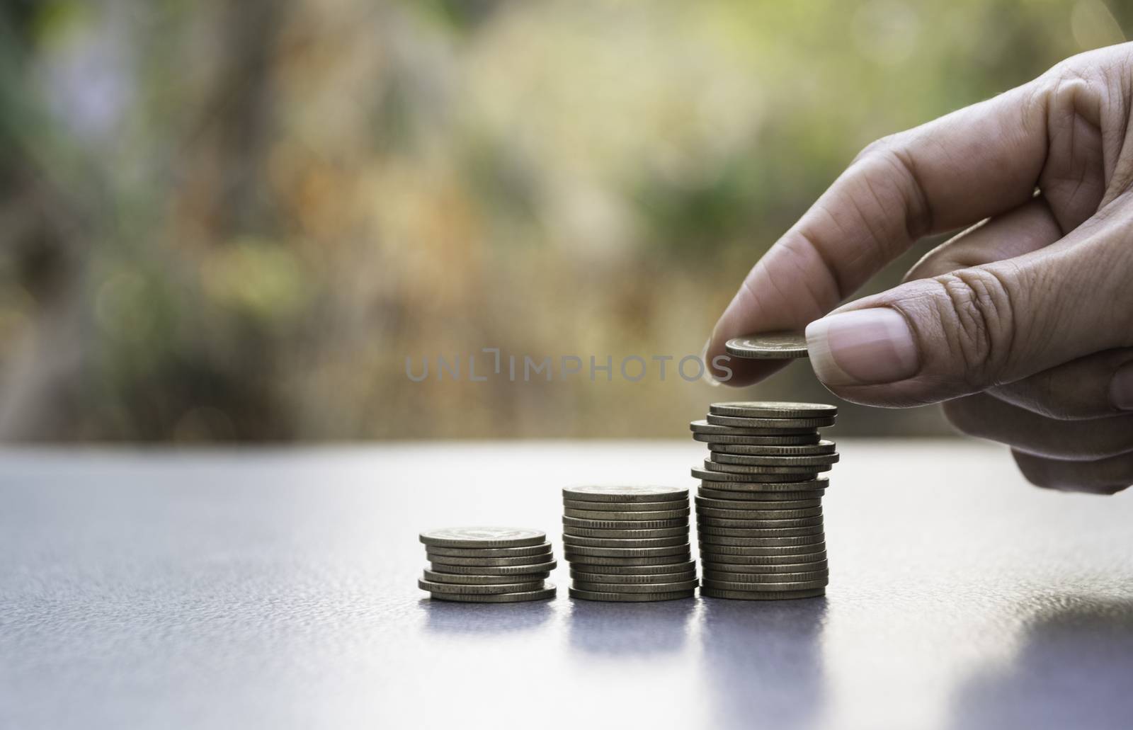 Hand drop a coin with money coin stack growing for business. financial and accounting concept.