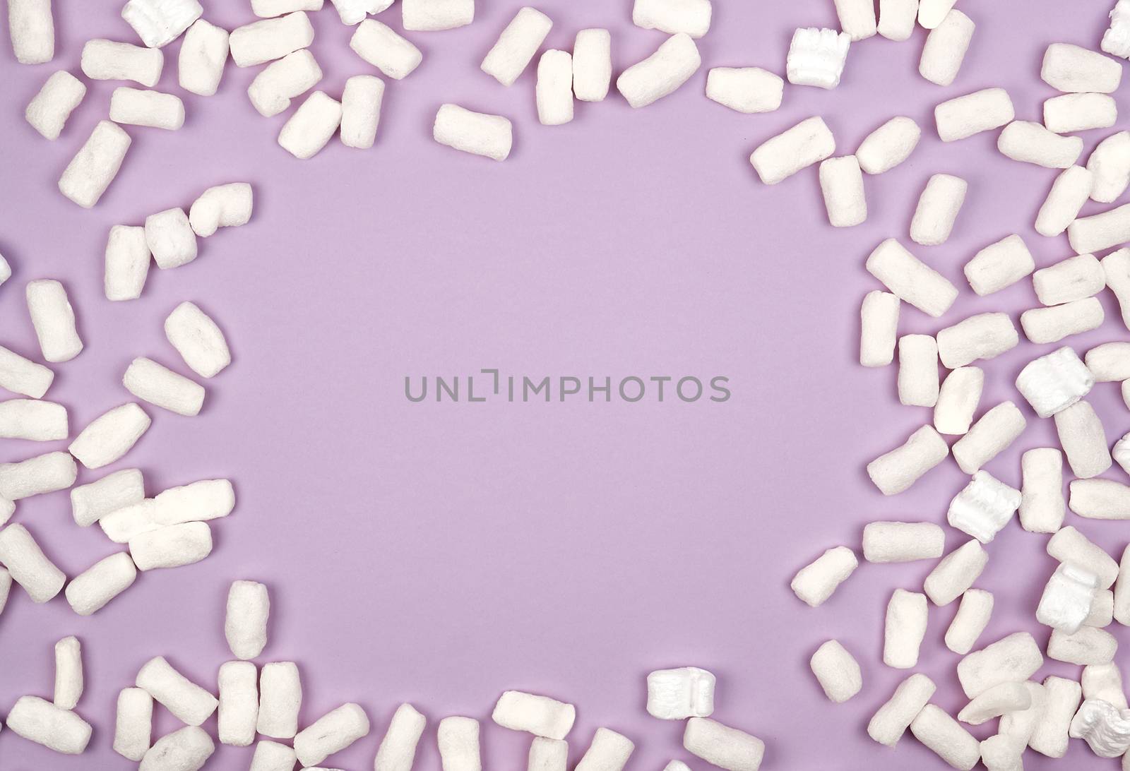 white foam filler for filling parcels during transportation on a lilac background, copy space
