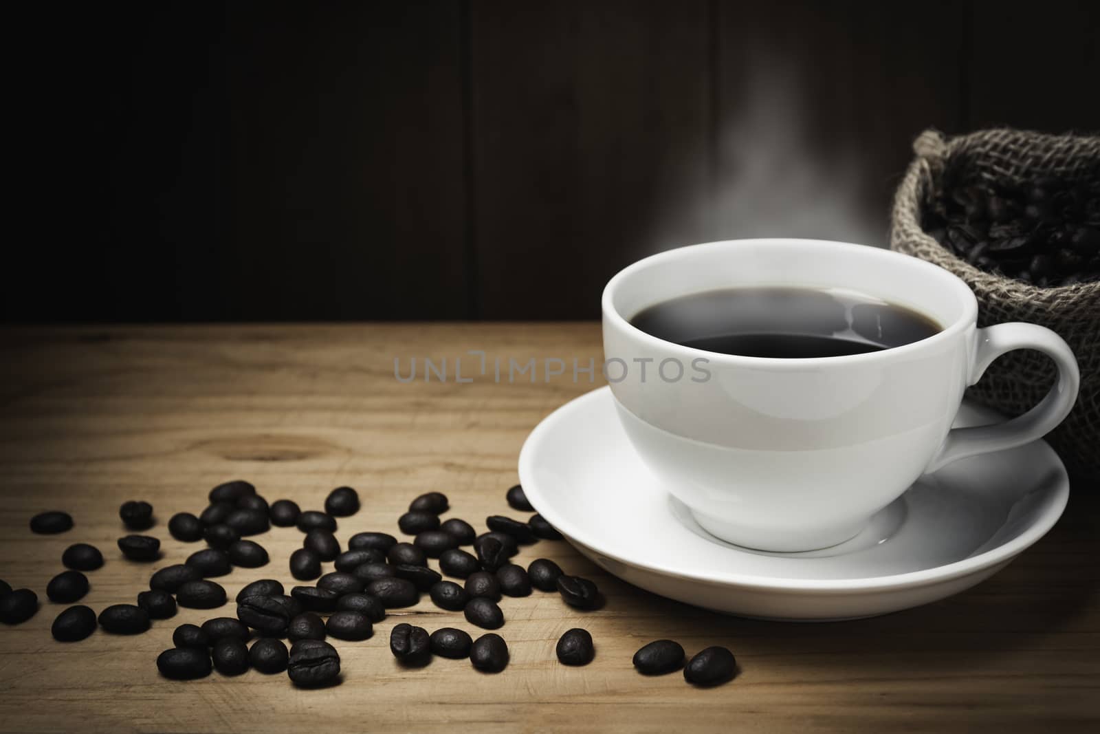 Wooden table desk with coffee. Coffee beans and coffee cup on wooden background with copy space.