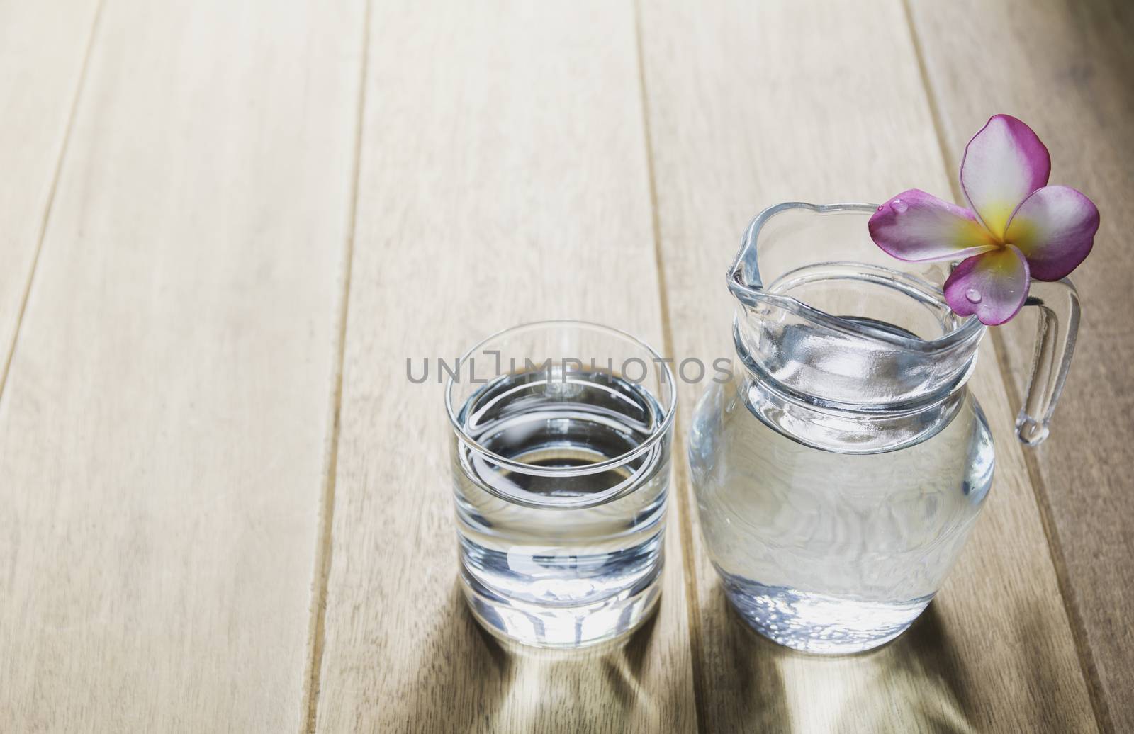 Water glass with glass jar on wooden table. Glass and clean drin by kirisa99