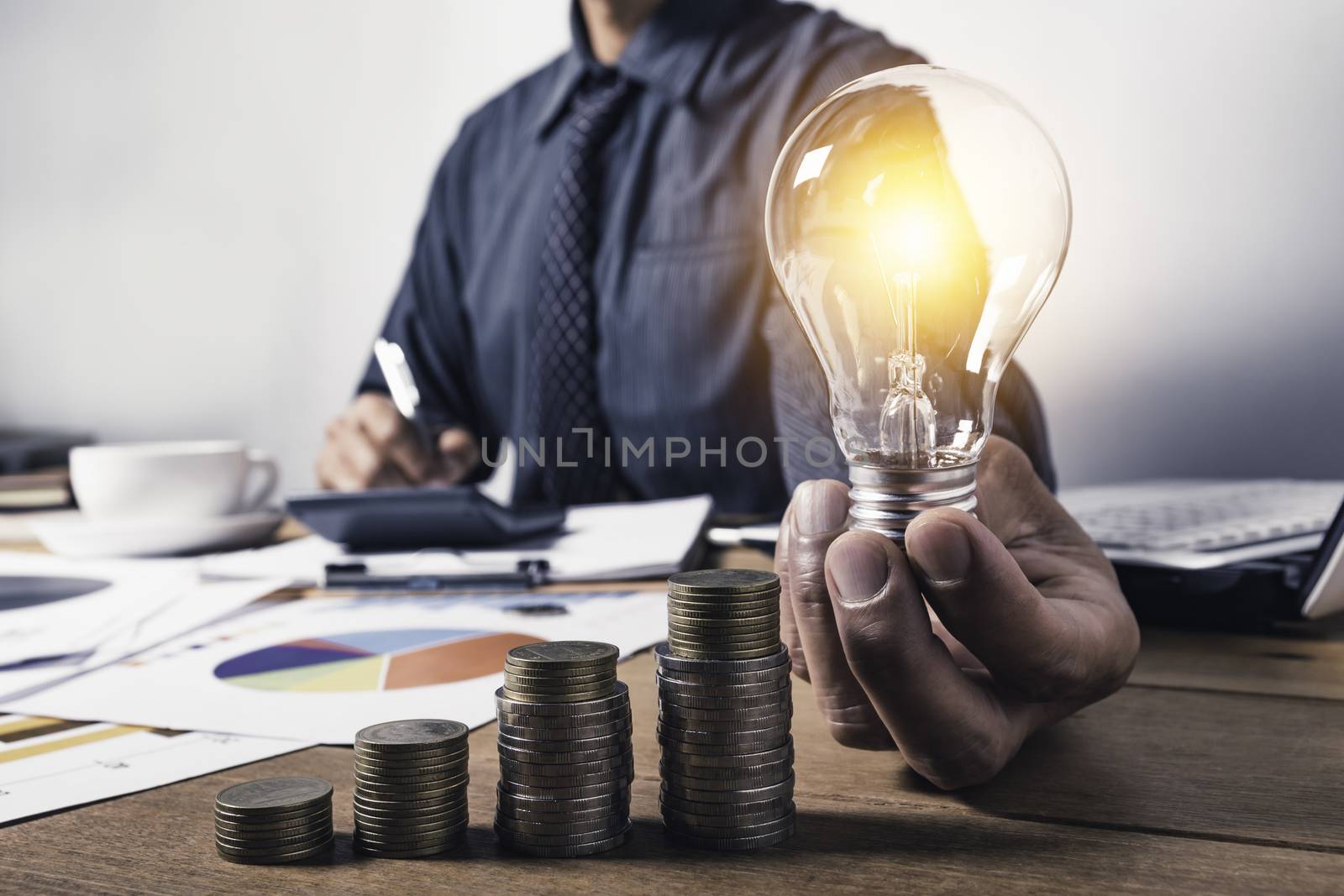 Business man holding a light bulb with coins money and copy spac by kirisa99