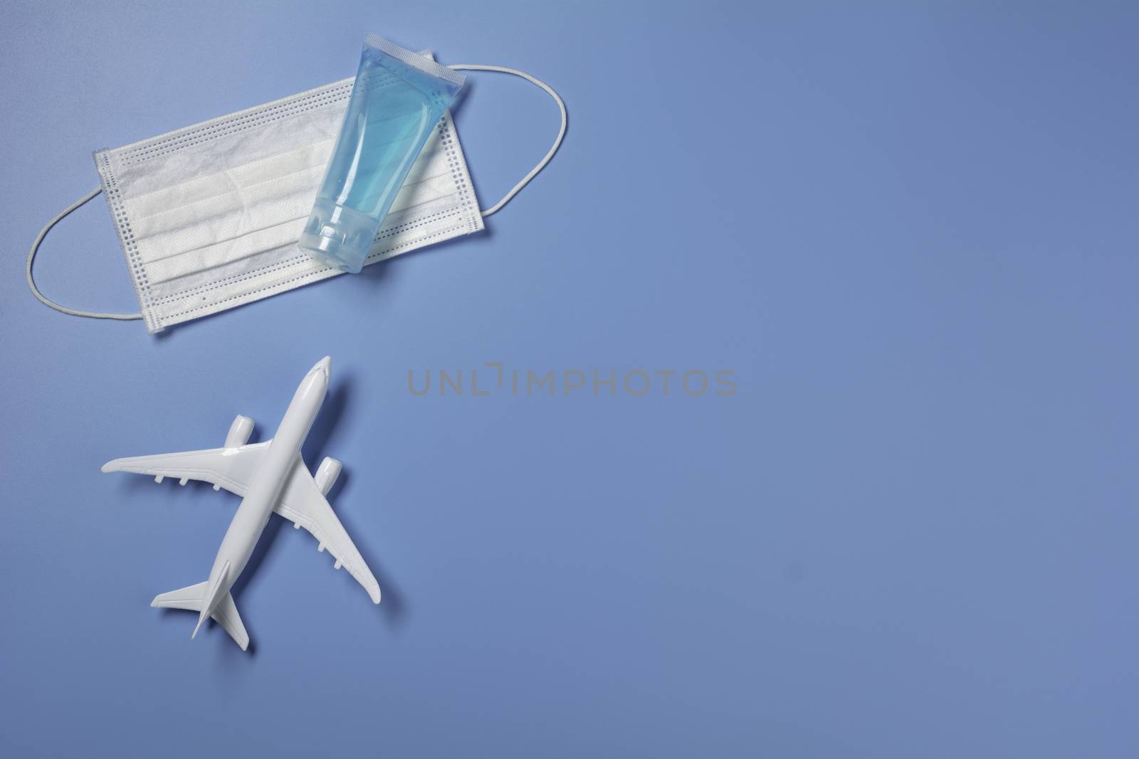 A toy airplane with medical mask for protecting virus and dust. Travel and protection concept.