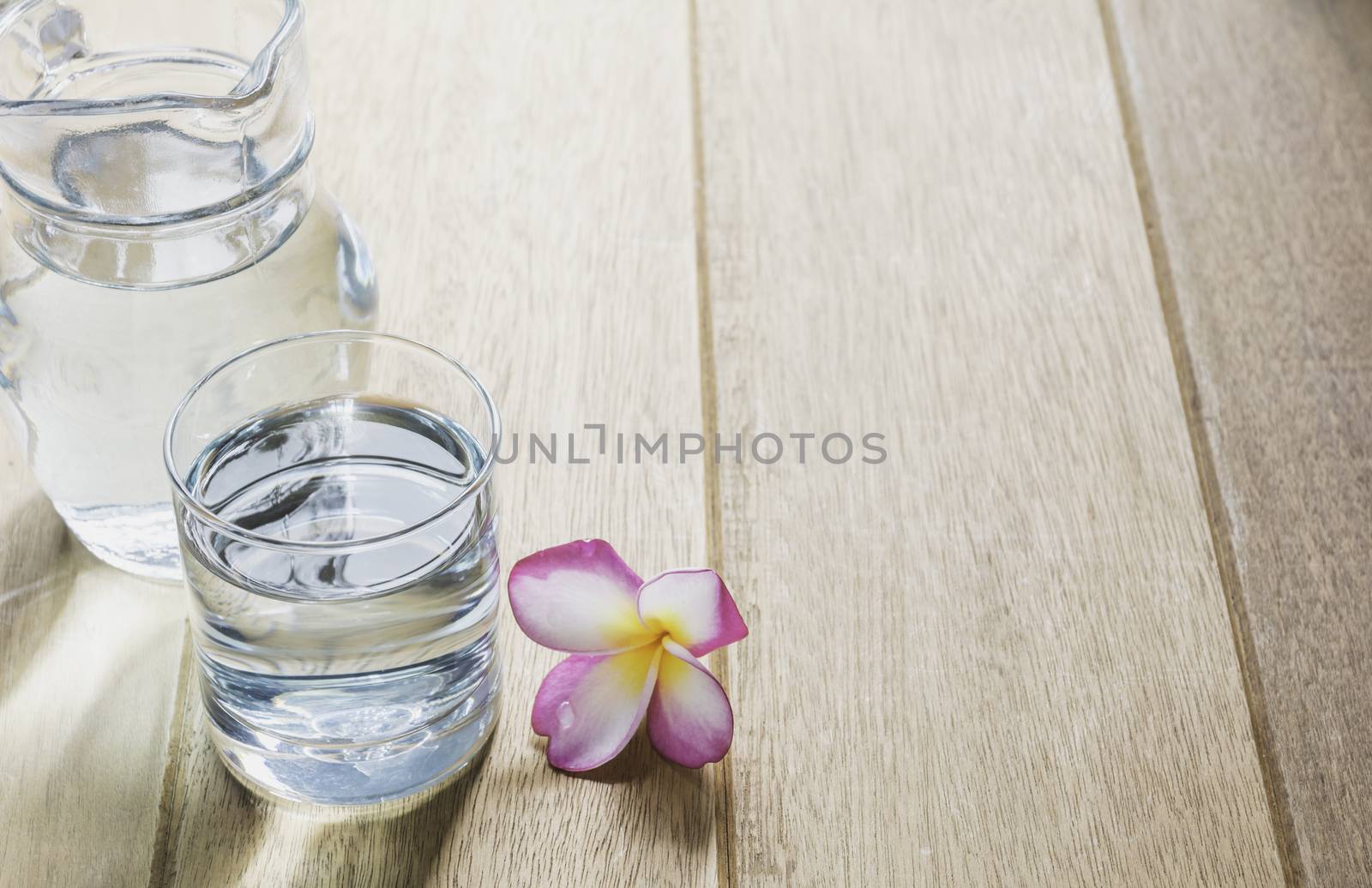 Water glass with glass jar on wooden table. Glass and clean drin by kirisa99