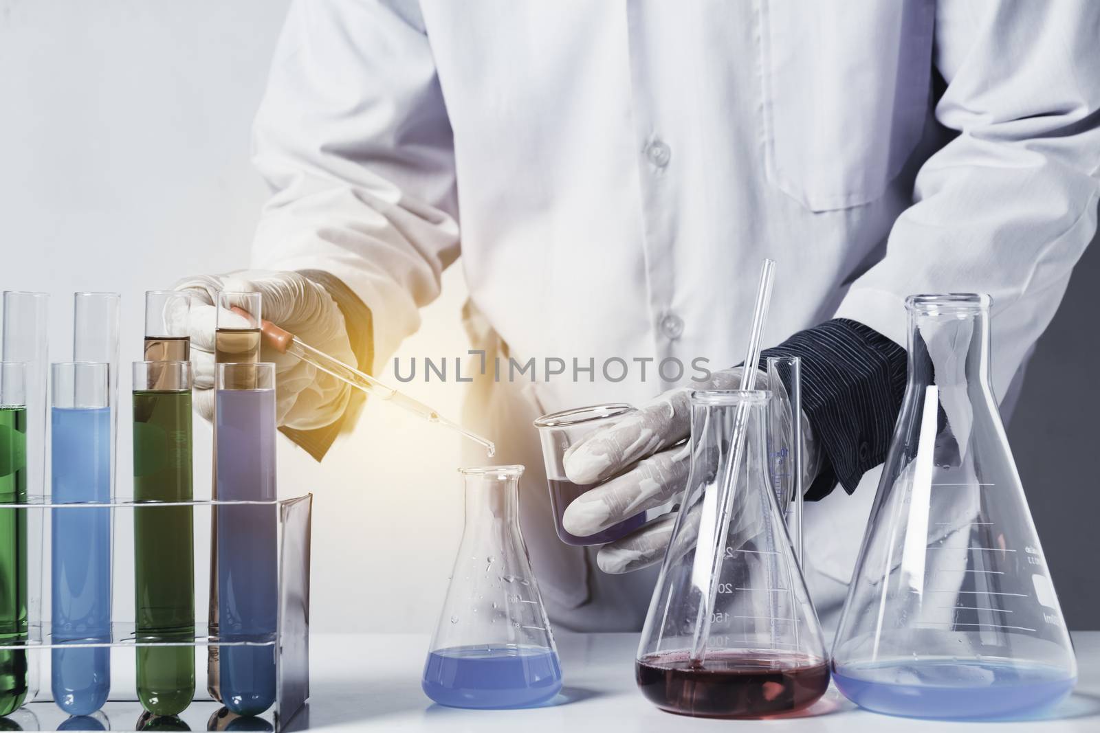 Researcher with glass laboratory chemical test tubes with liquid for analytical , medical, pharmaceutical and scientific research concept.