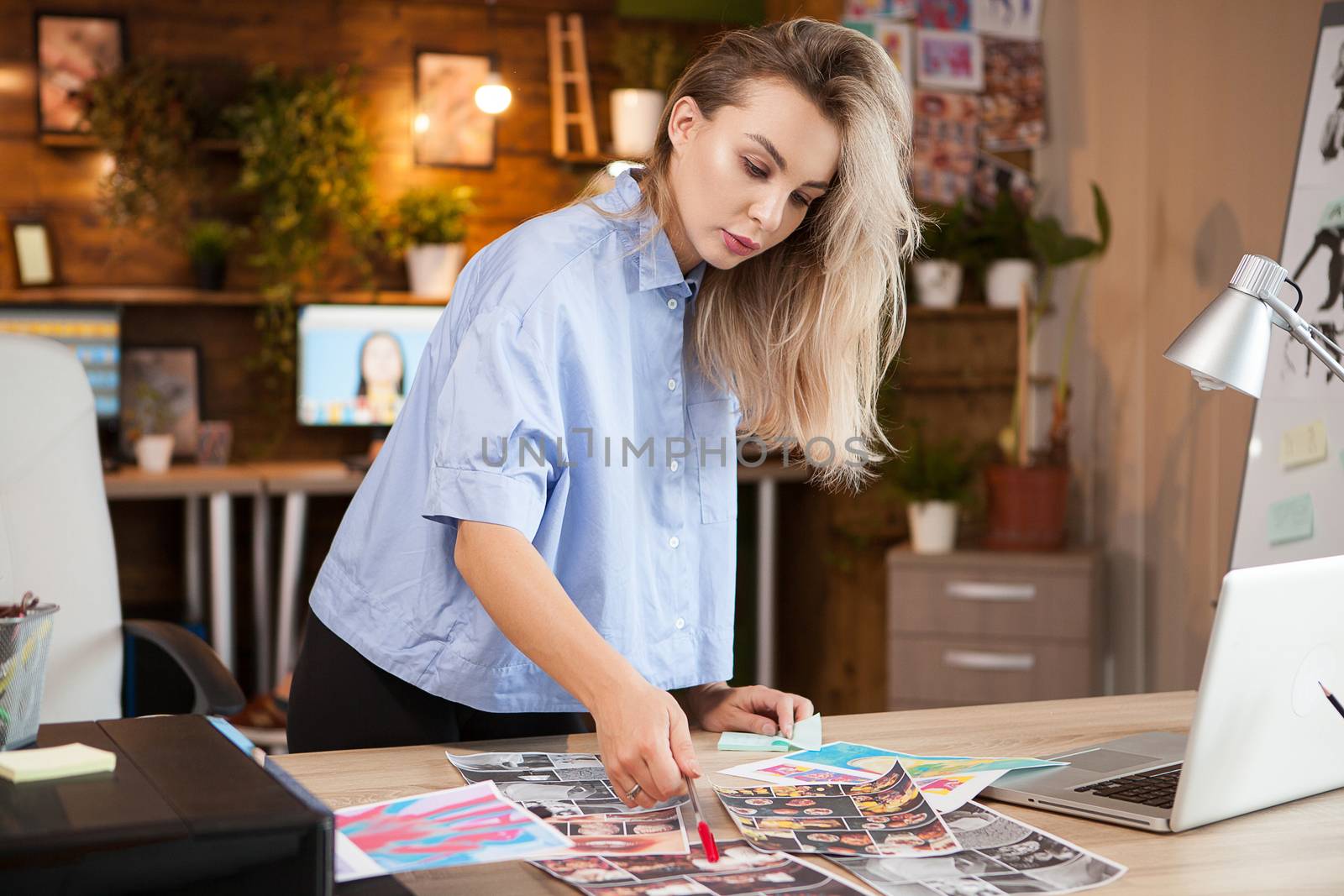 Caucasian female designer woman in creative office working on her designs.