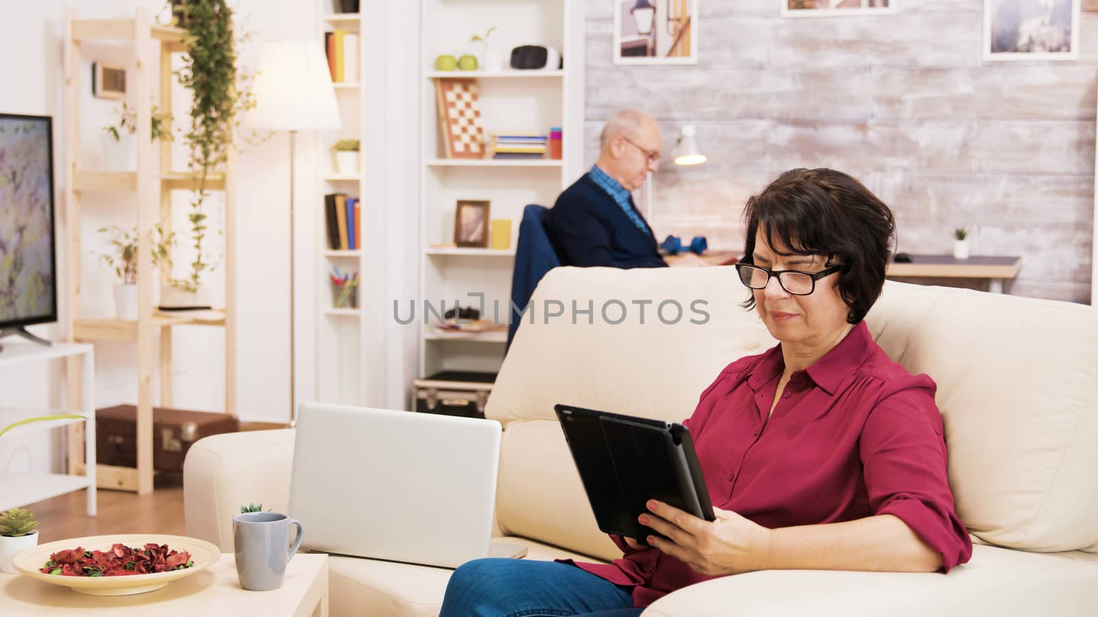 Zoom in shot of elderly age woman using tablet by DCStudio