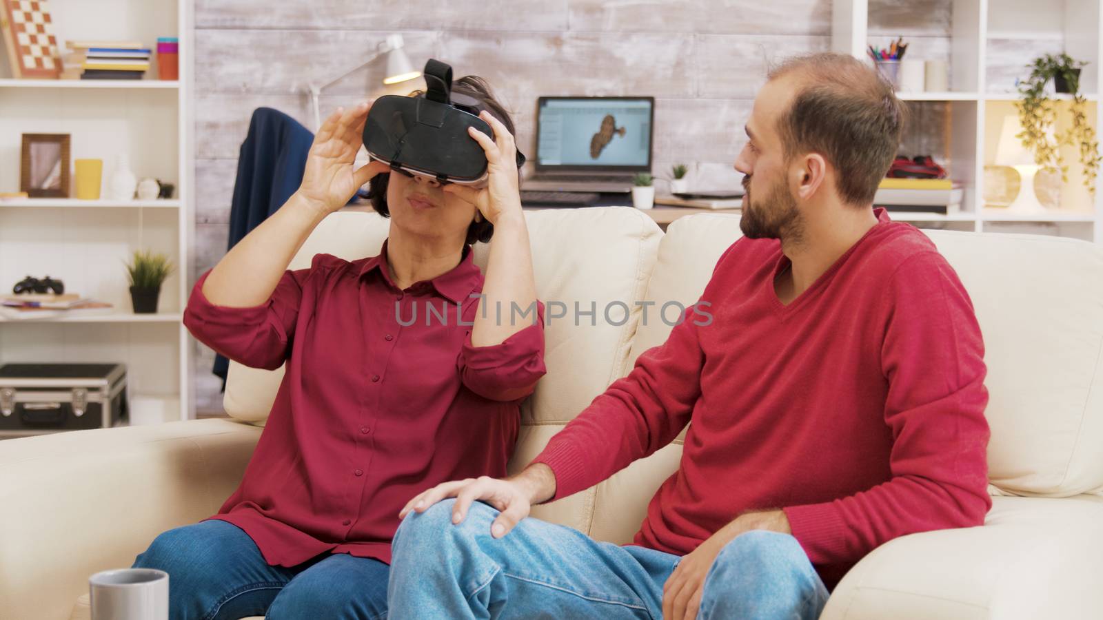 Nephew showing his grandmother how to use VR goggles by DCStudio