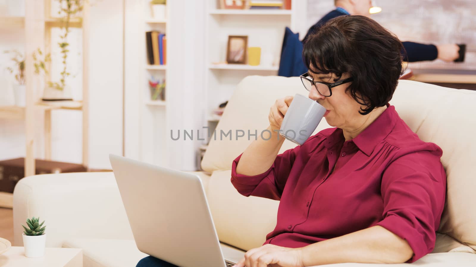 Side view of retired woman typing on laptop by DCStudio