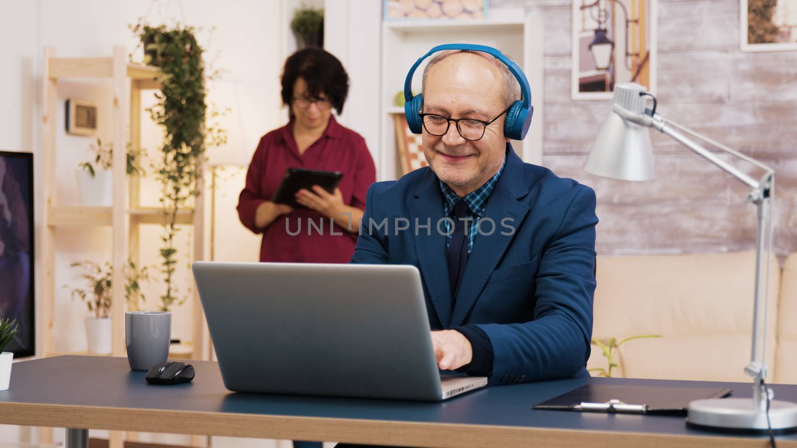 Senior old man listening music on headphones by DCStudio