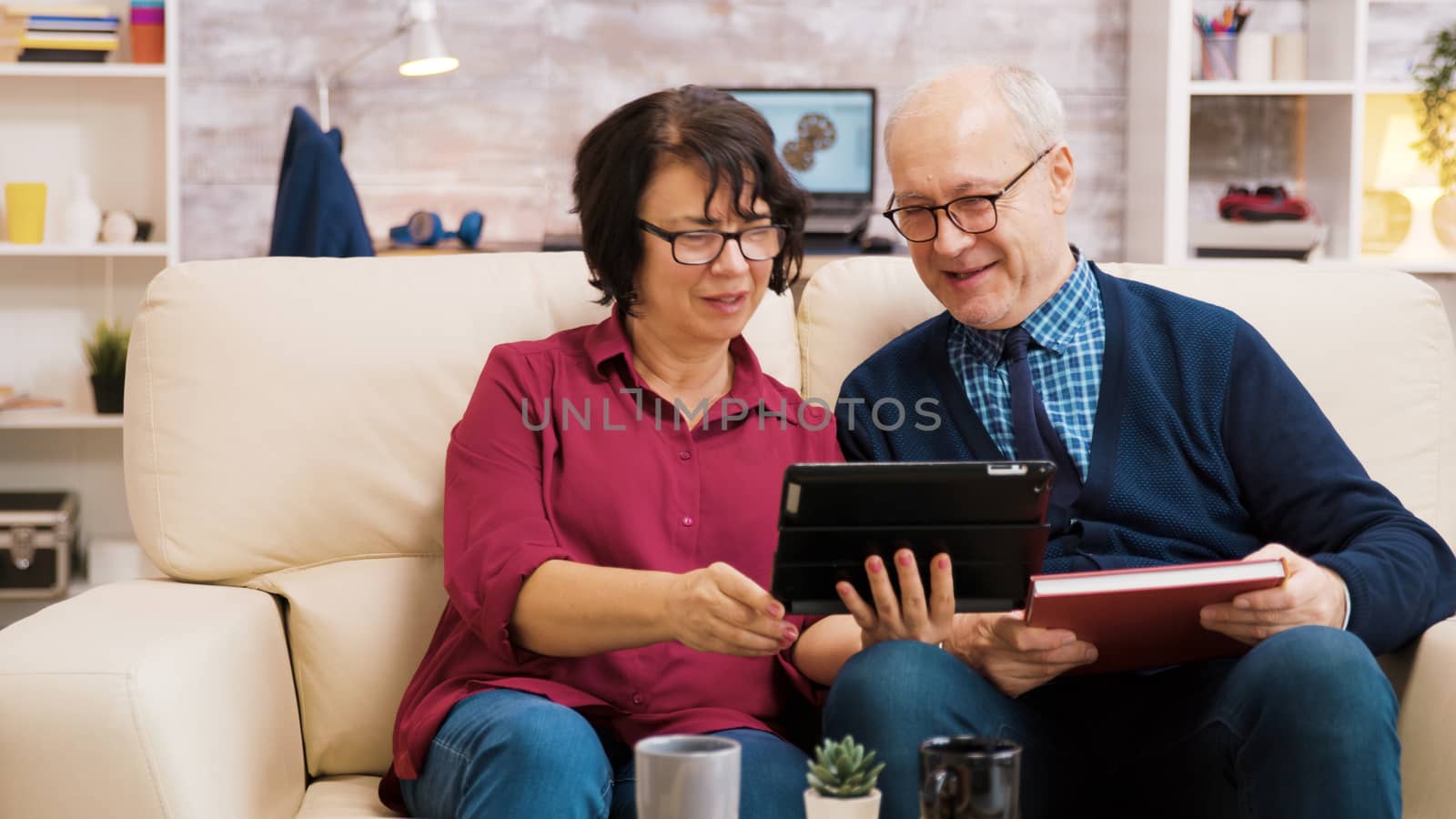 Senior couple waving at tablet during a video call by DCStudio