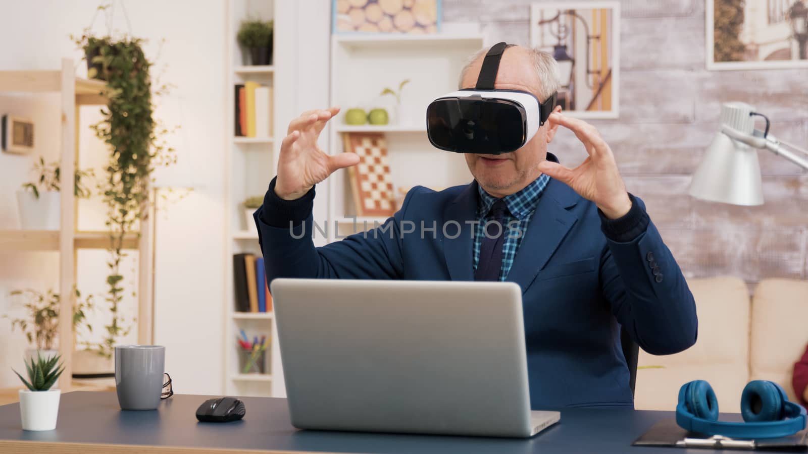 Retired man experiencing virtual reality using vr headset in living room. Cup of coffee on the table.