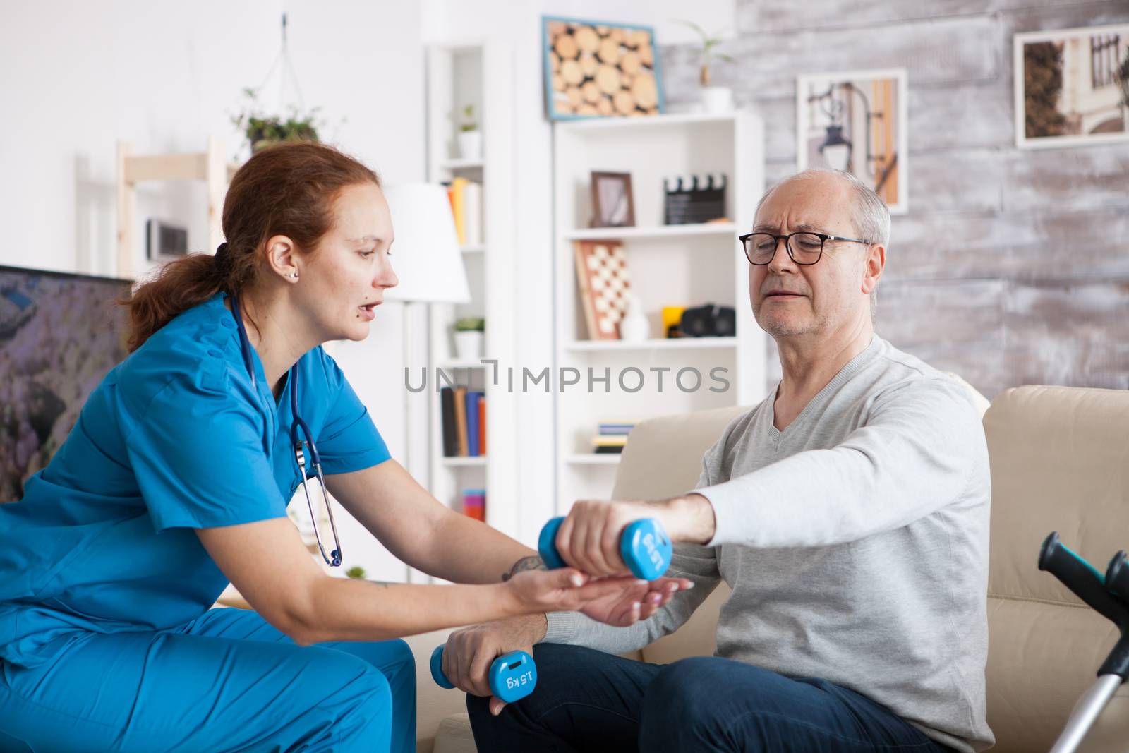 Senior man in nursing home doing physiotherapy by DCStudio
