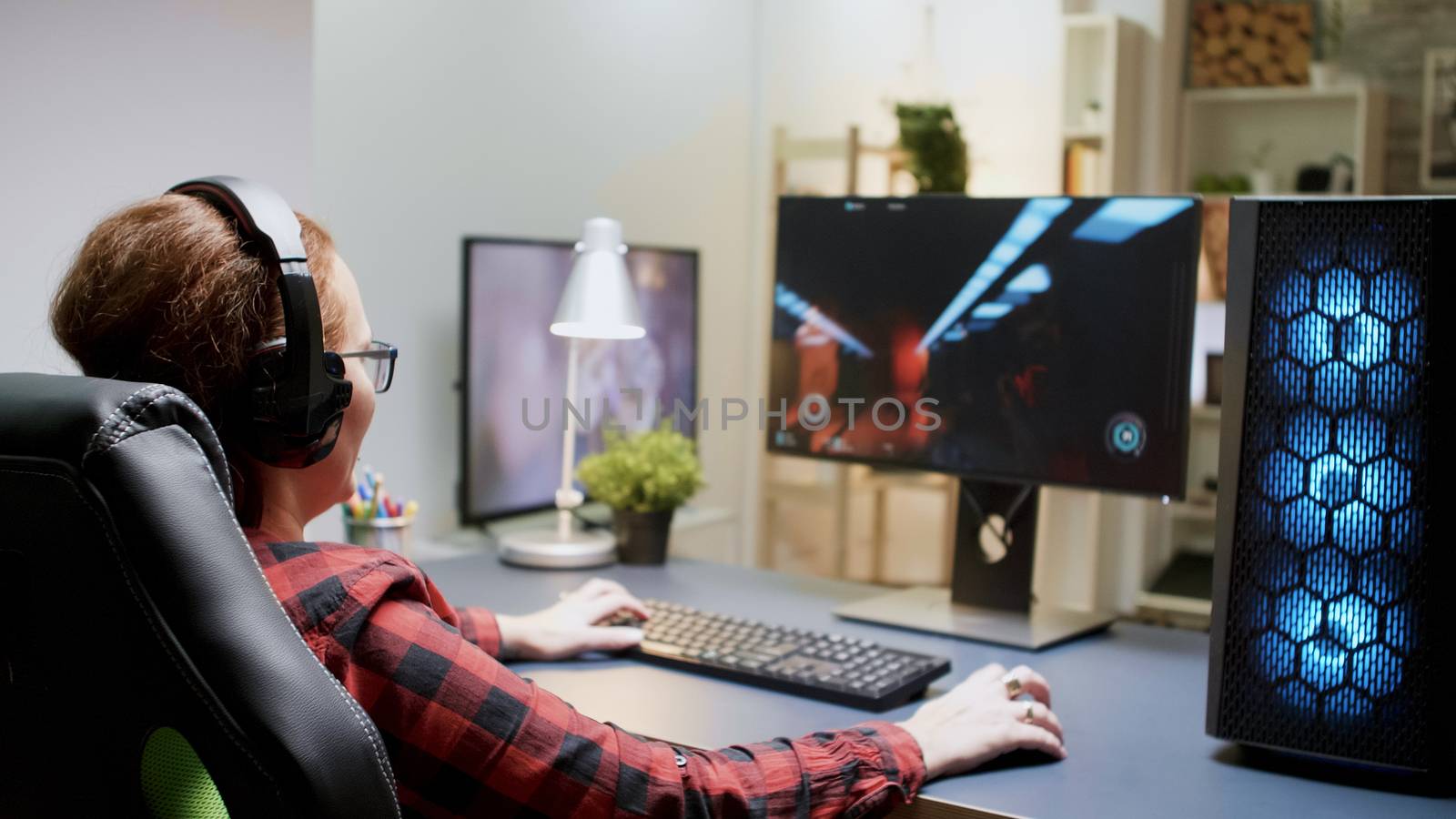 Woman with red hair upset she lost on a shooter online game sitting on gaming chair with headphones on.