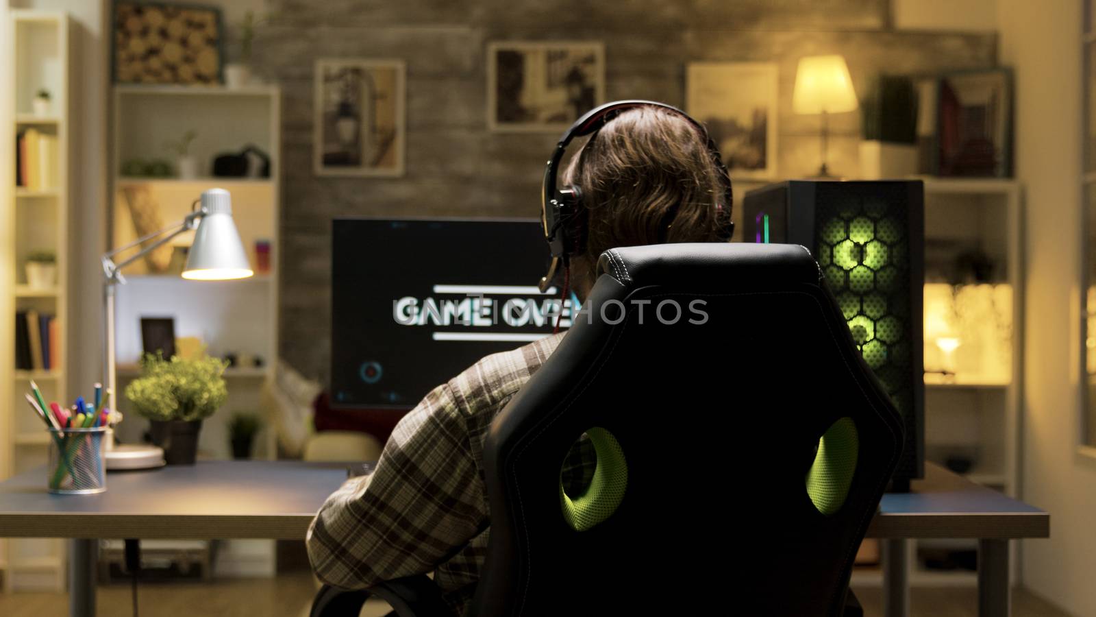 Over shoulder shot of man after losing at video games by DCStudio