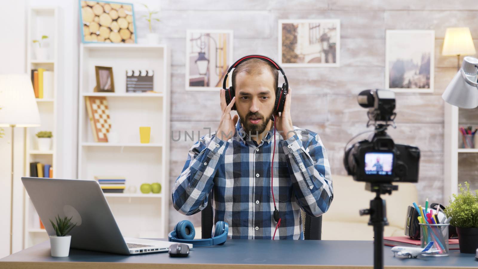 Famous vlogger recording a review and testing headphones. Creative content creator.