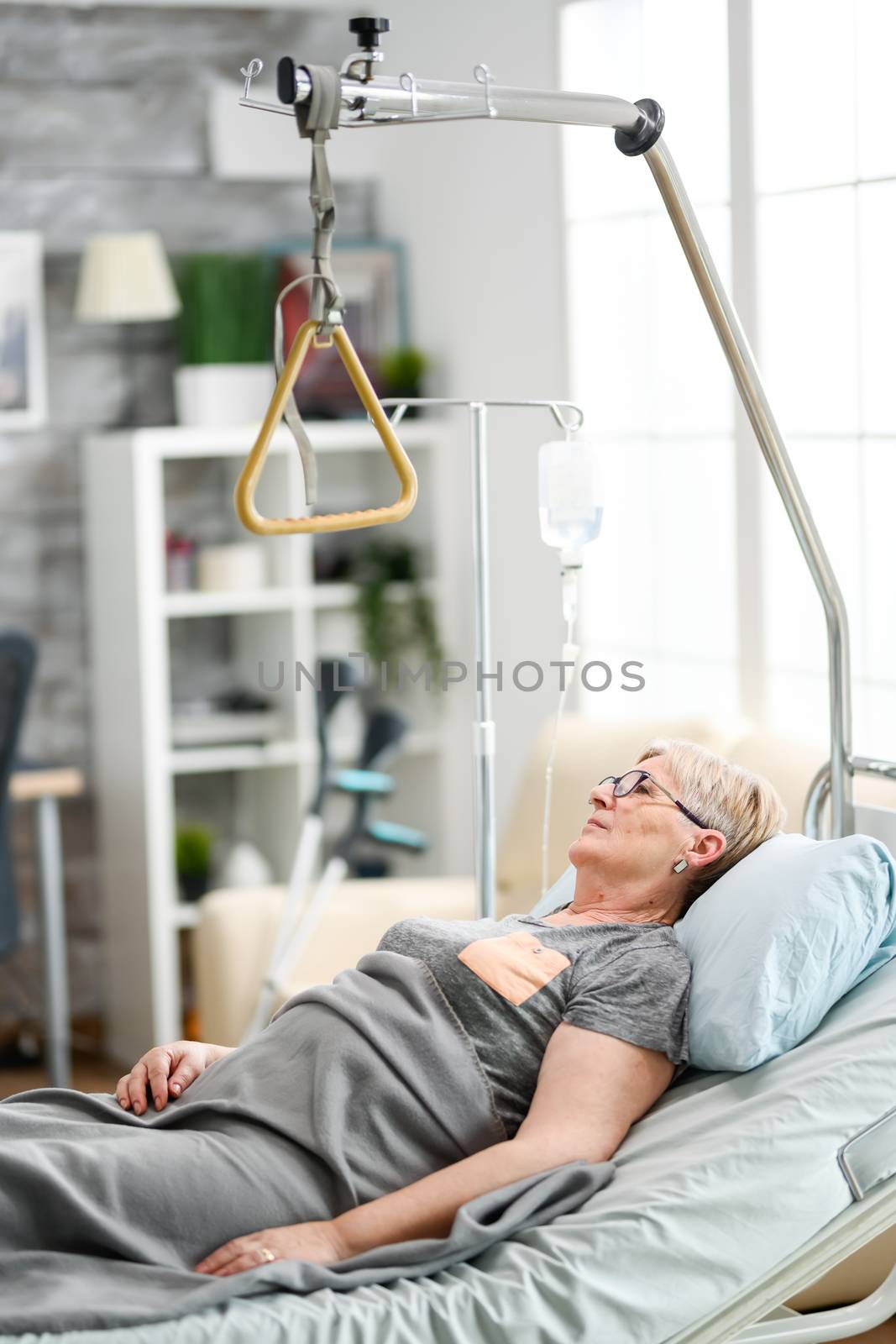 Retired old woman lying peacefully in a nursing home bed. Aged granny in nursing home.