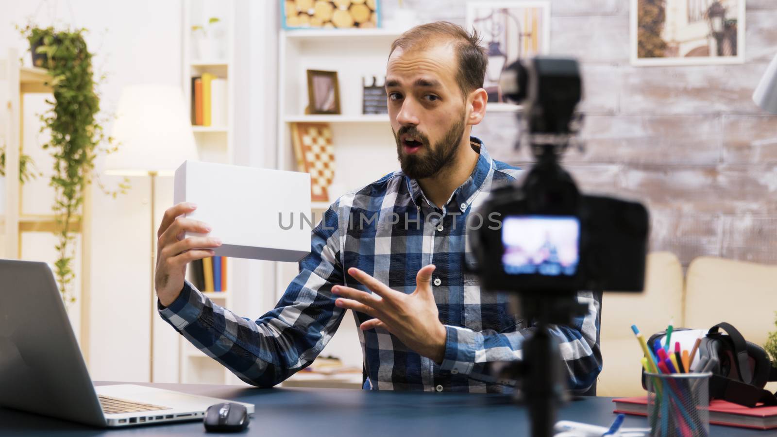 Excited young vlogger making a review of a product inside of white box. Creative content creator.