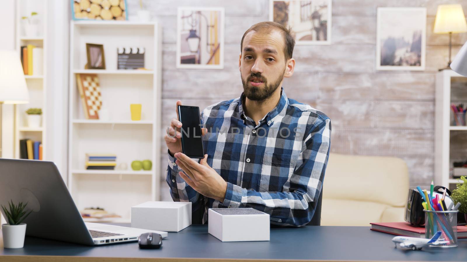 Male vlogger recording the unboxing of new phone. Famous content creator.