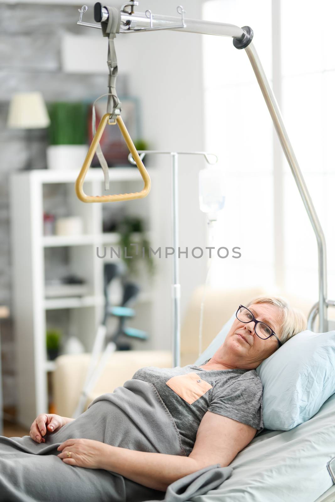 Elderly female patient in a nursing home resting in bed.