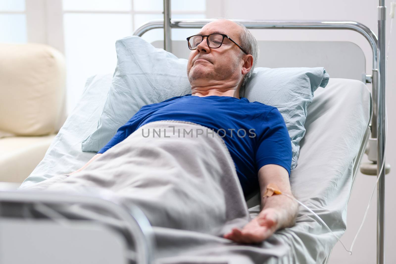 Peaceful retired old man in a nursing home laying in bed.