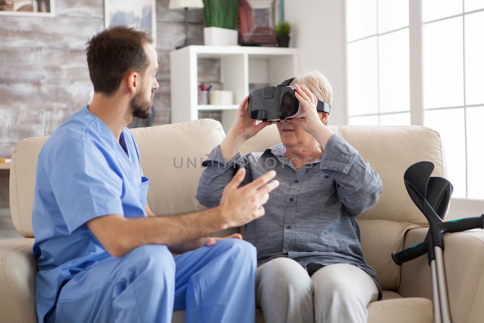 Senior woman in nursing amased while using vr glasses. Young doctor and elderly age woman.