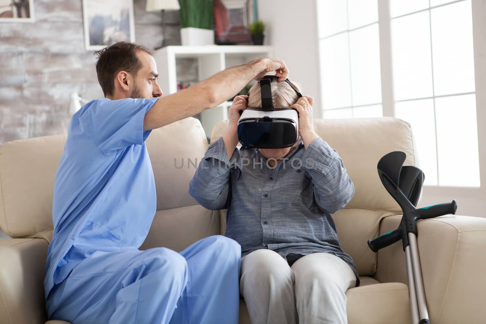 Young doctor putting virtual reality glasses on senior woman by DCStudio