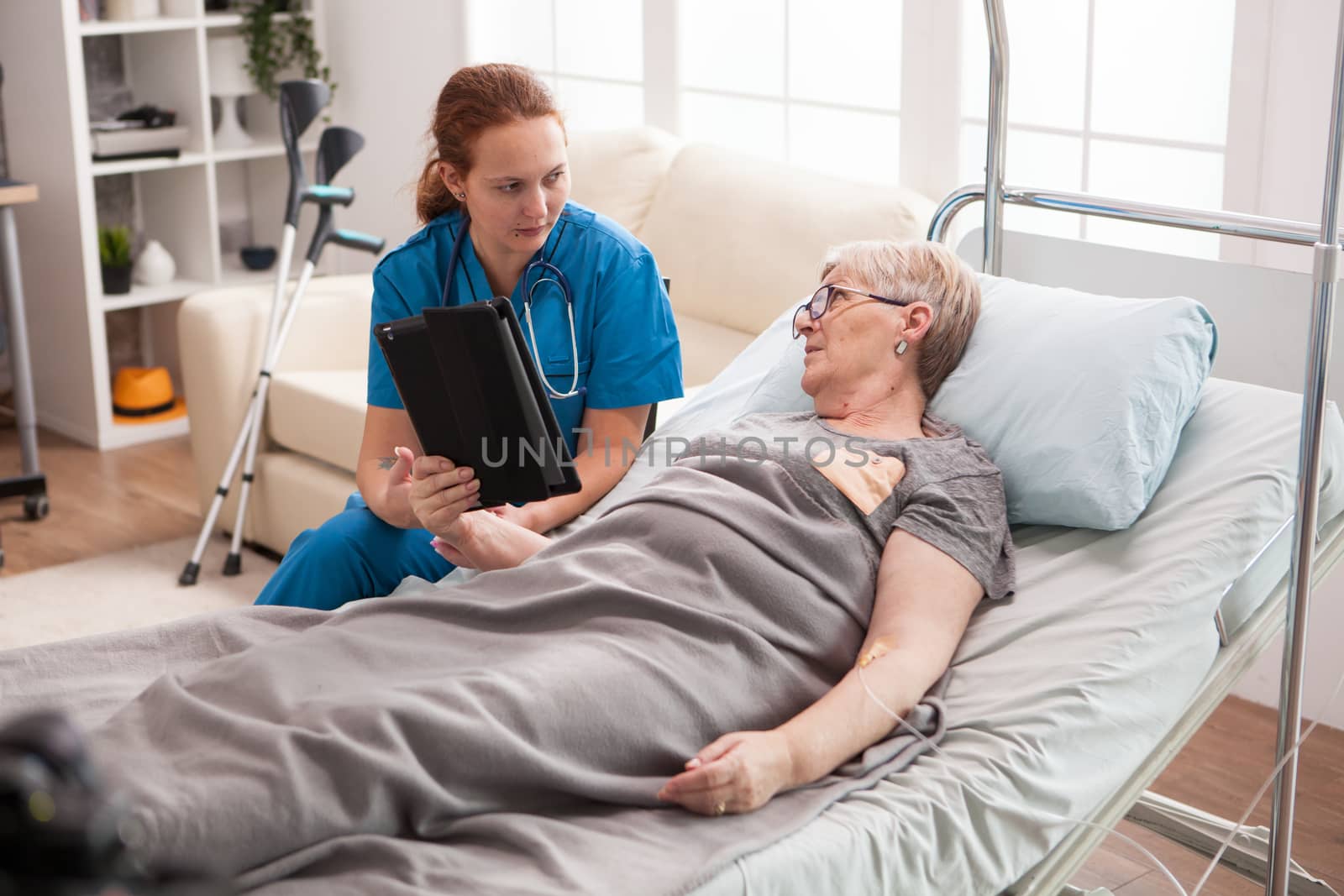 Female doctor in nursing home using tablet computer by DCStudio