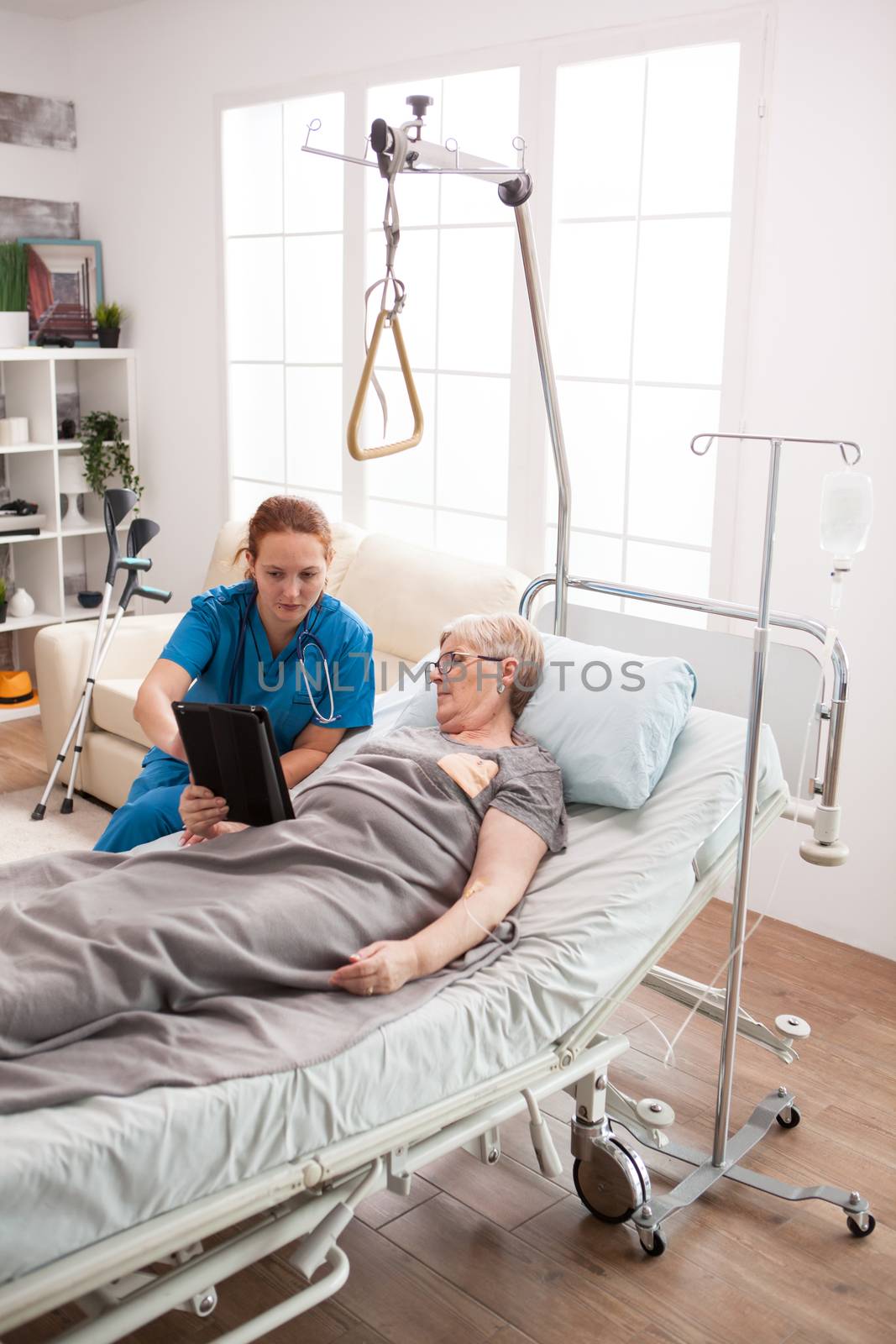 Female caretaker and senior woman using tablet computer by DCStudio