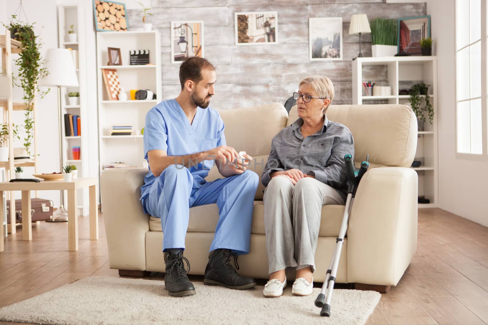 Doctor in nursing home talking with senior woman by DCStudio