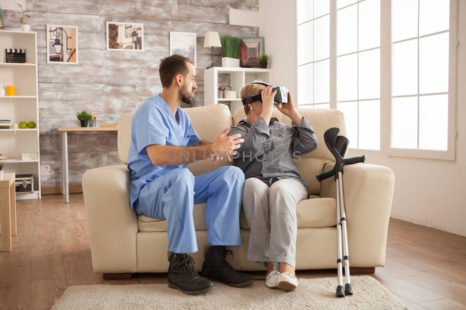 Cheerful senior woman in nursing home using vr headset.