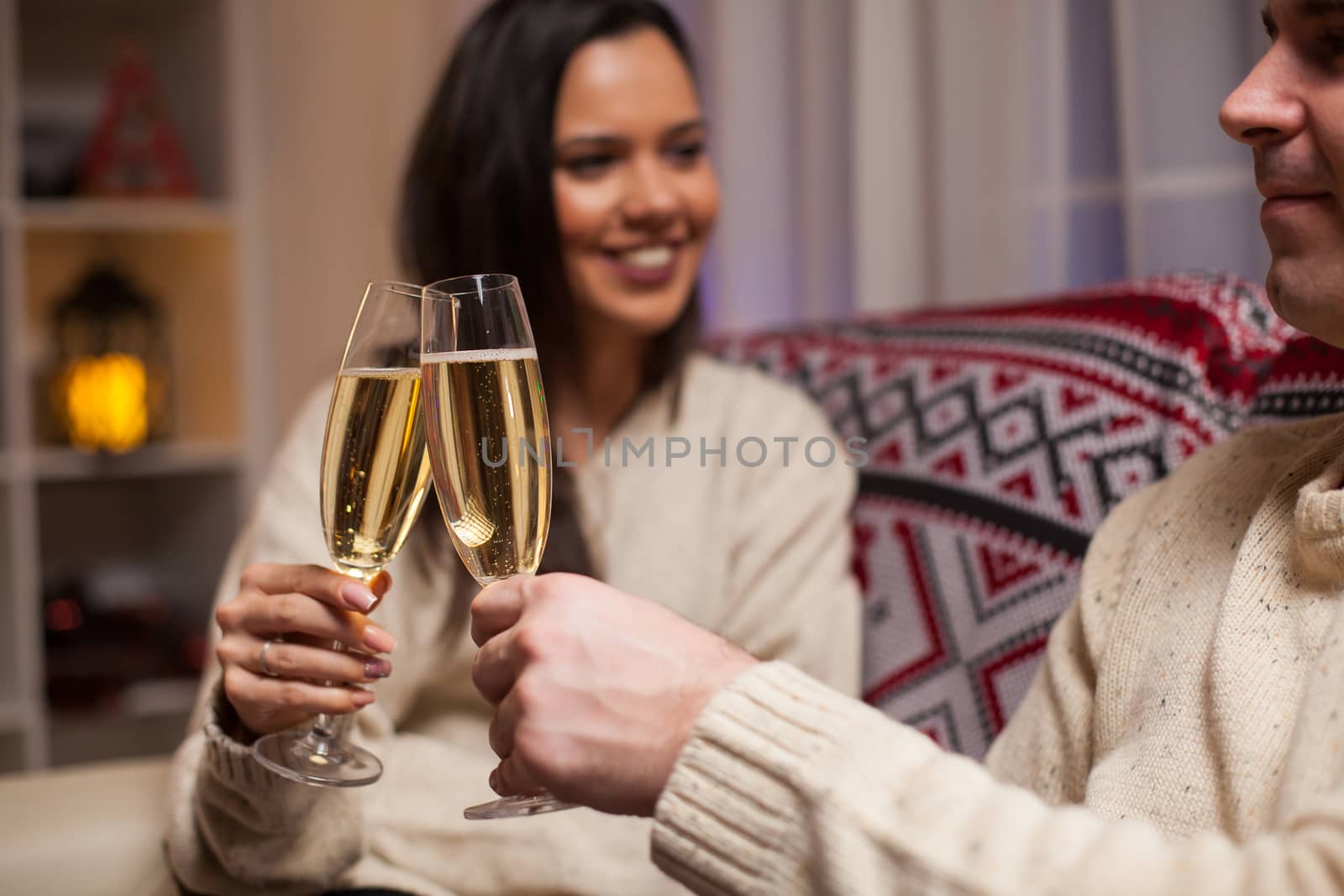 Caucasian couple celebrating their relationship on christmas day clinking a glass of champagne.