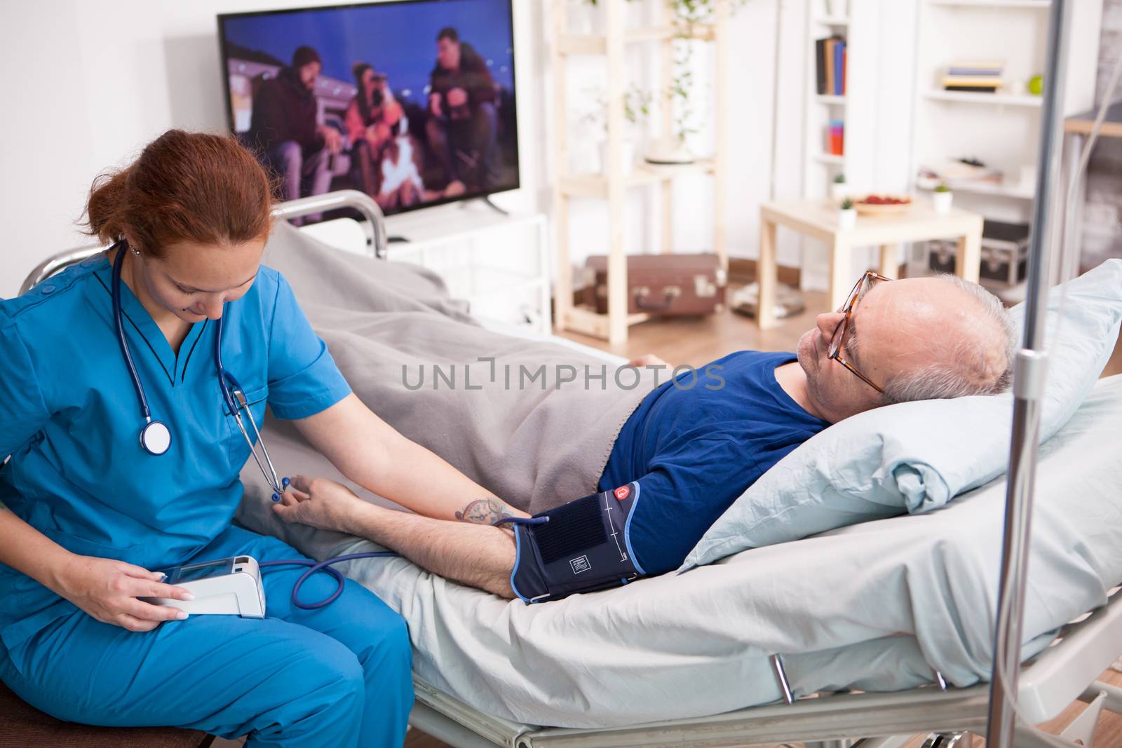 Female doctor reading blood pressure of old man by DCStudio