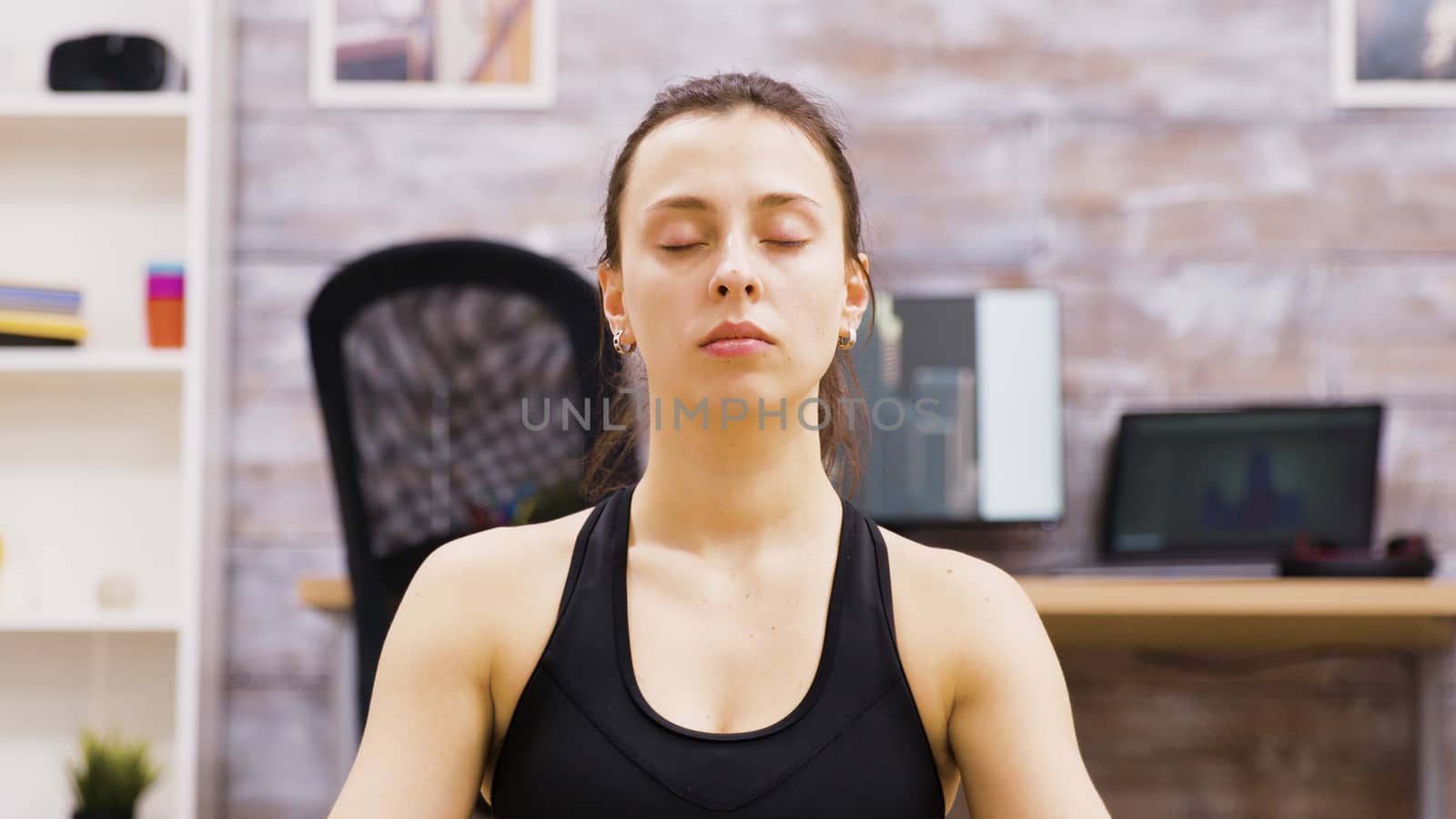 Caucasian woman in living room breathing slowly in lotus yoga poisition.