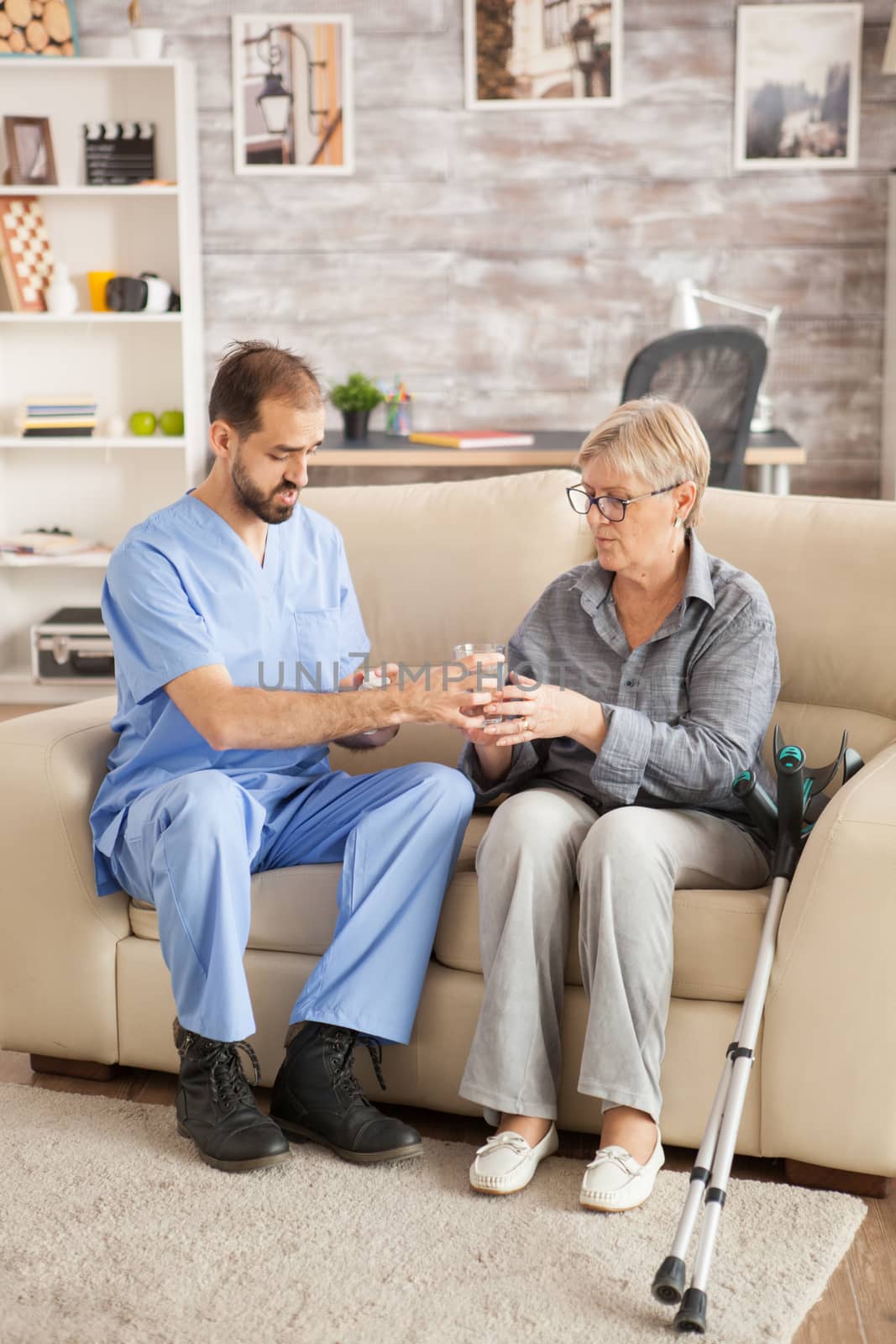 Doctor in nursing home helping senior woman by DCStudio