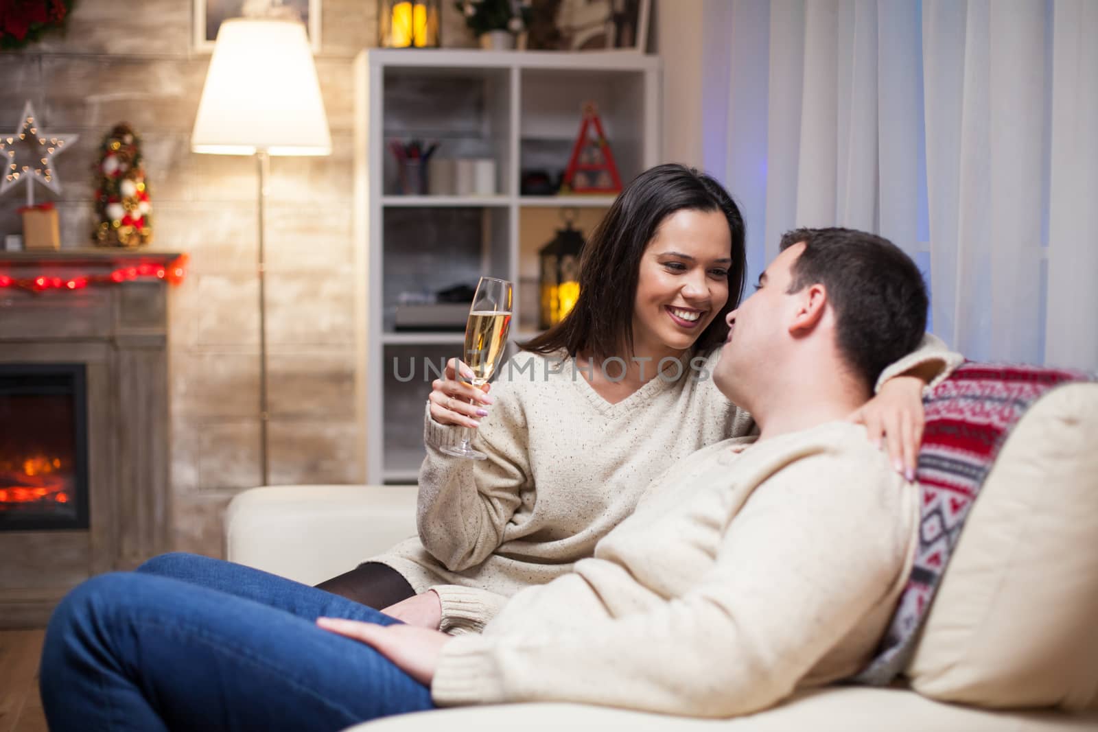 Relaxed couple sitting on couch celebrating christmas day.