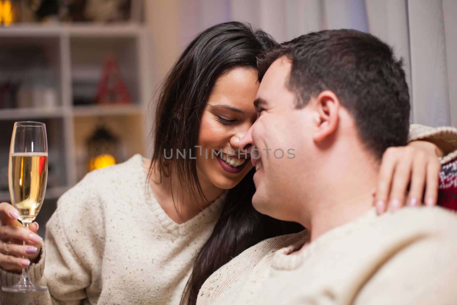 Portrait of young woman smiling on christmas day giving love to her husband.