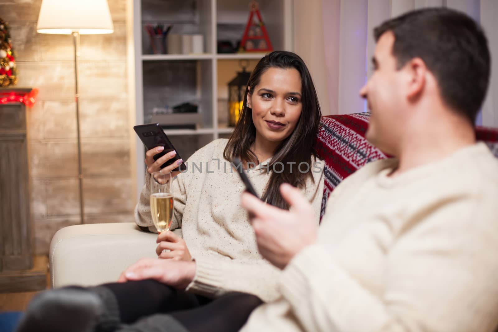 Young couple having a conversation holding their phones by DCStudio