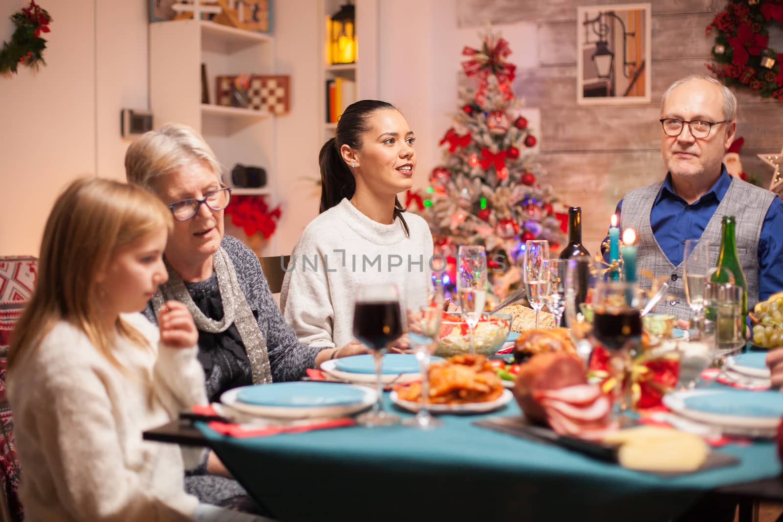 Cheerful woman at the table with her family at christmas dinner.