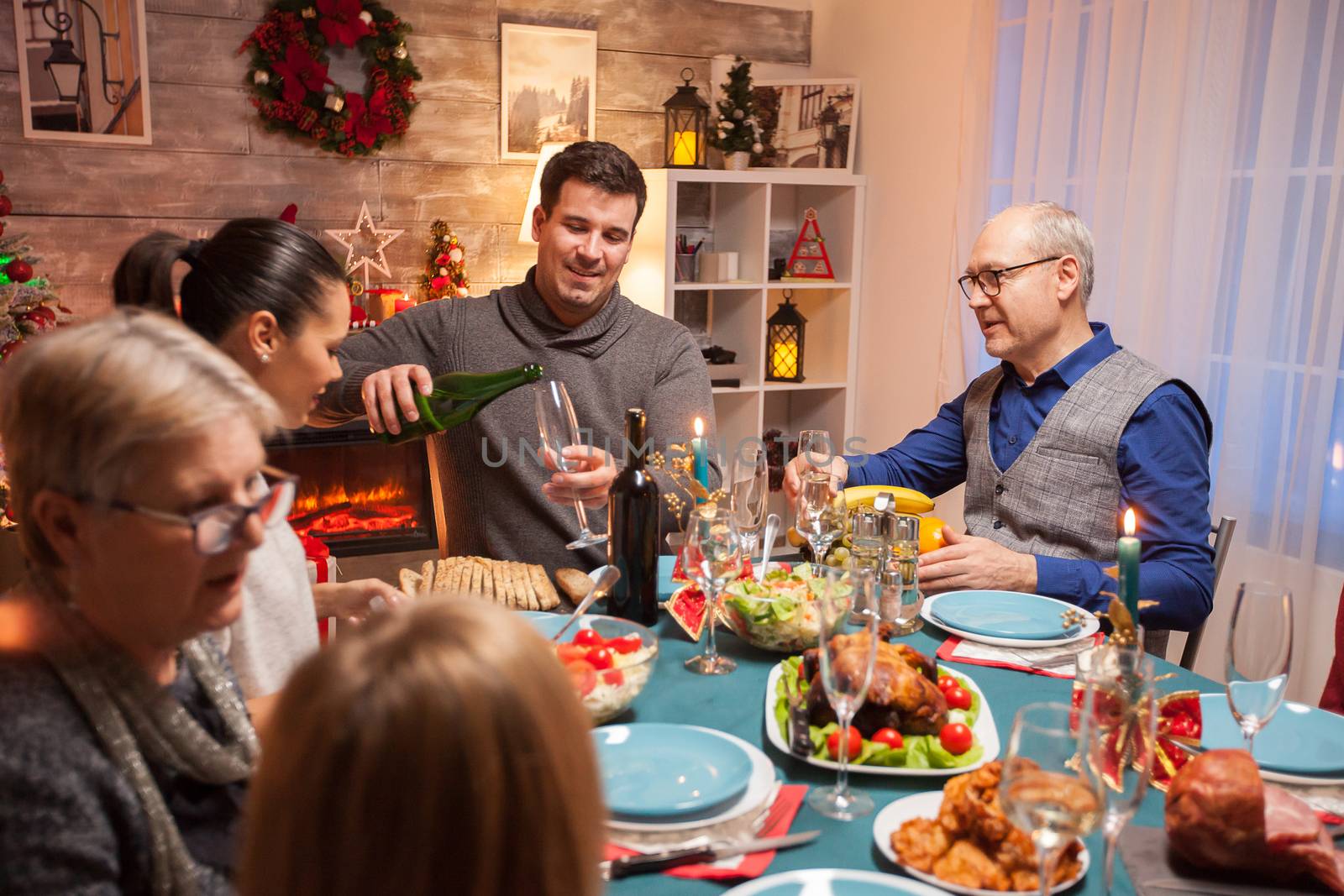 Husband pouring wine for his father in law by DCStudio