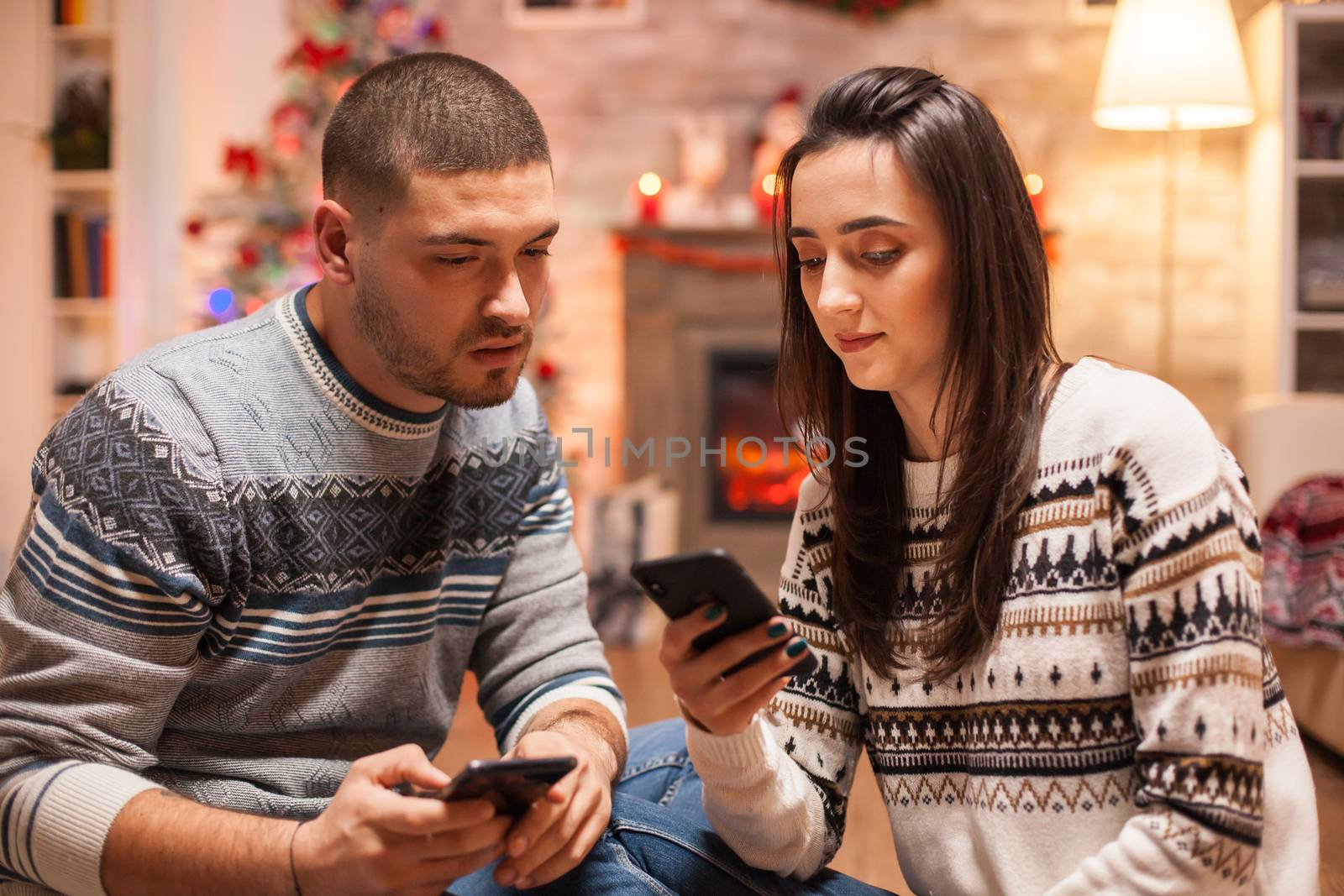Loving couple browsing on phone for a christmas vacation.