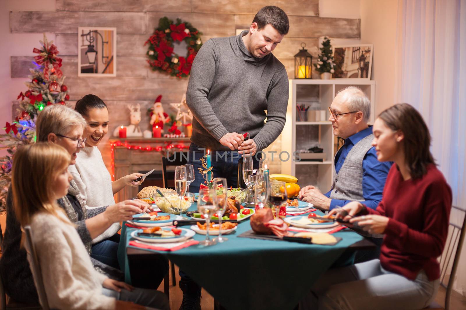 Father opening a bottle of wine by DCStudio