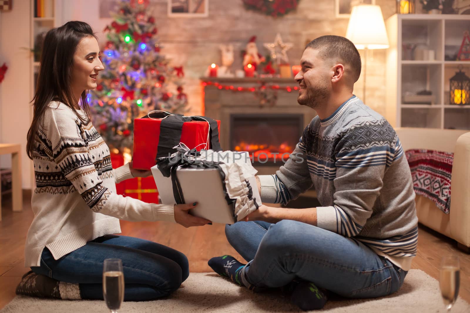 Cheerful boyfriend giving his girlfriend a gift by DCStudio