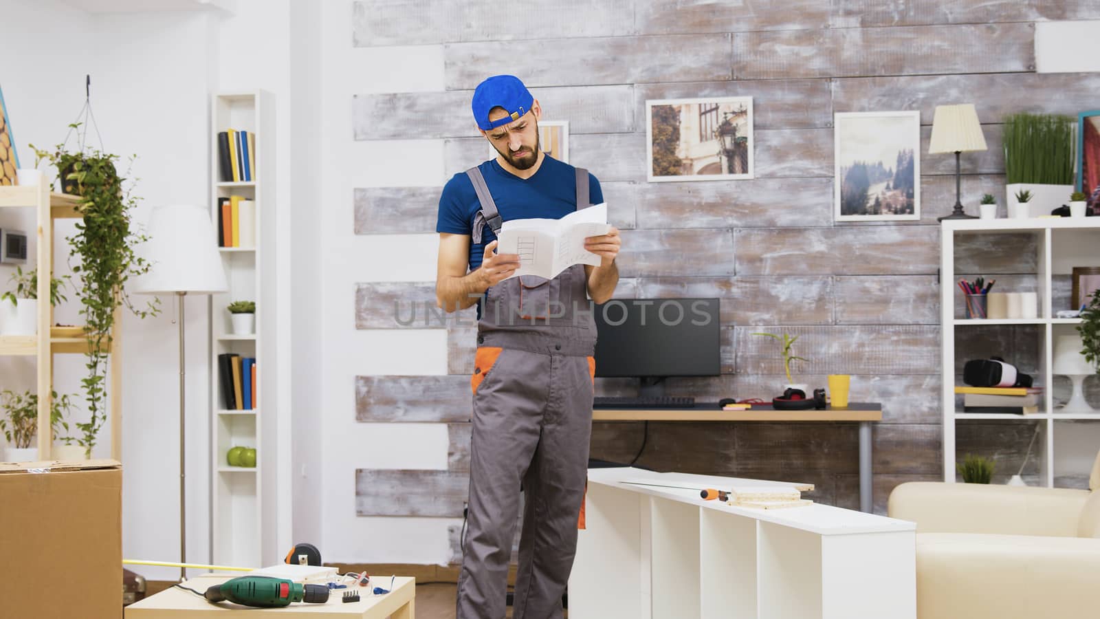 Confused furniture assembly worker while reading instructions and leaving the people apartment.