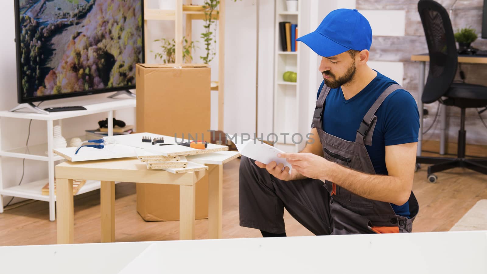 Professional furniture assembly worker checking position of the shelf. Worker follows instruction.