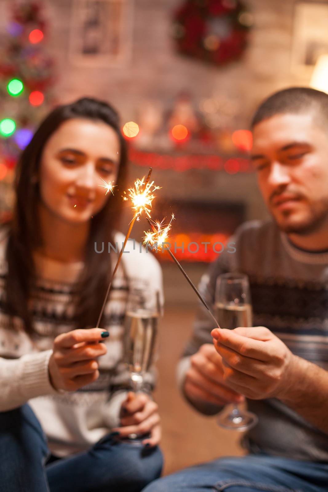 Glowing hand fireworks holded by young couple by DCStudio