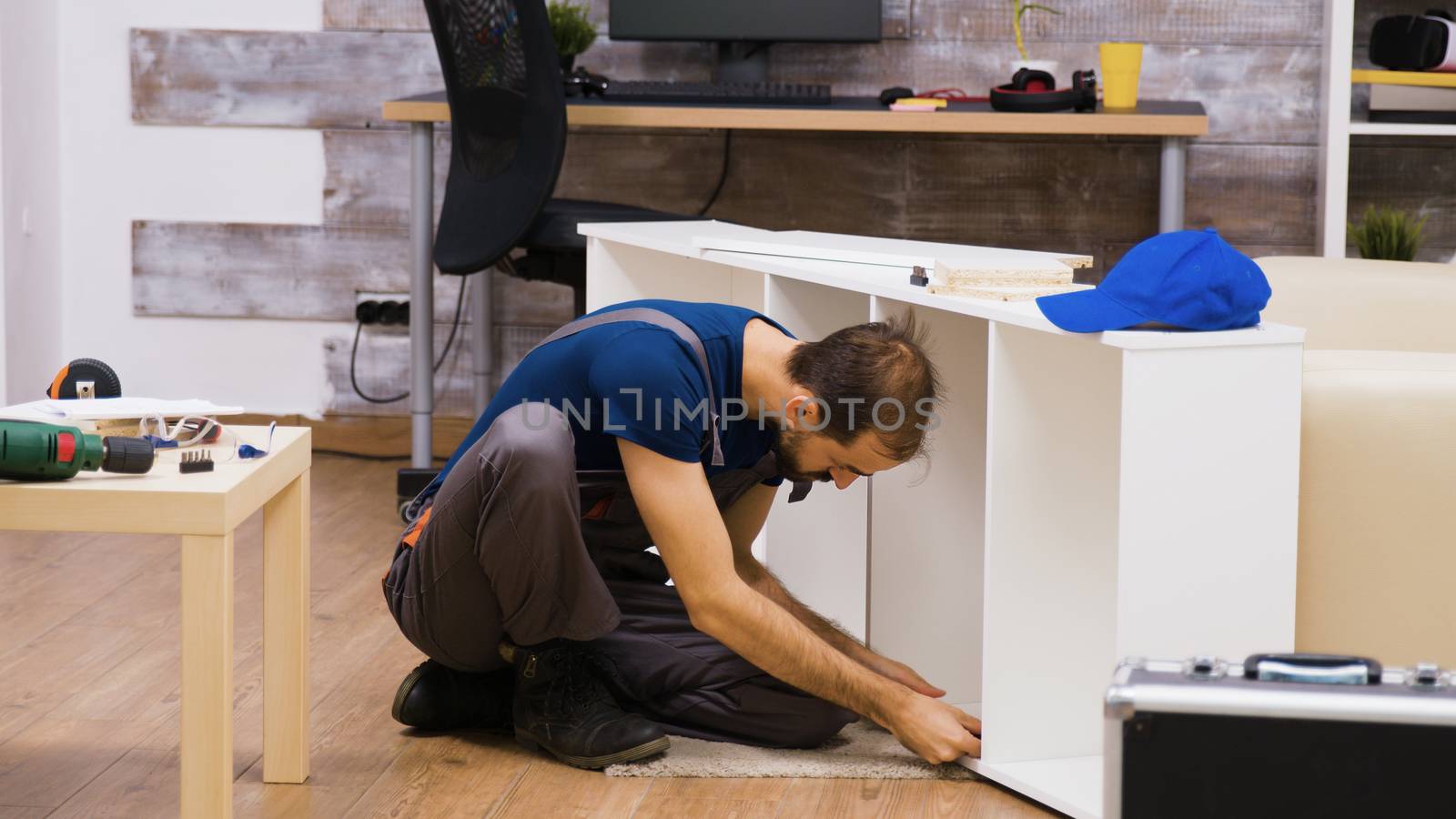 Male worker showing thumb sign after assambles a shelf on new furniture for home owners.