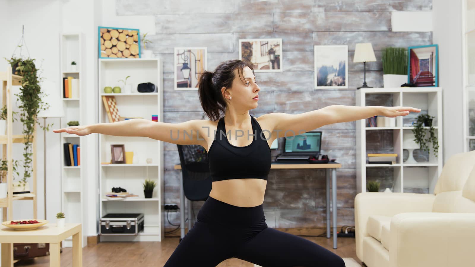 Young woman keeping her eyes closed standing in yoga pose. Woman keeping a healthy lifestyle.