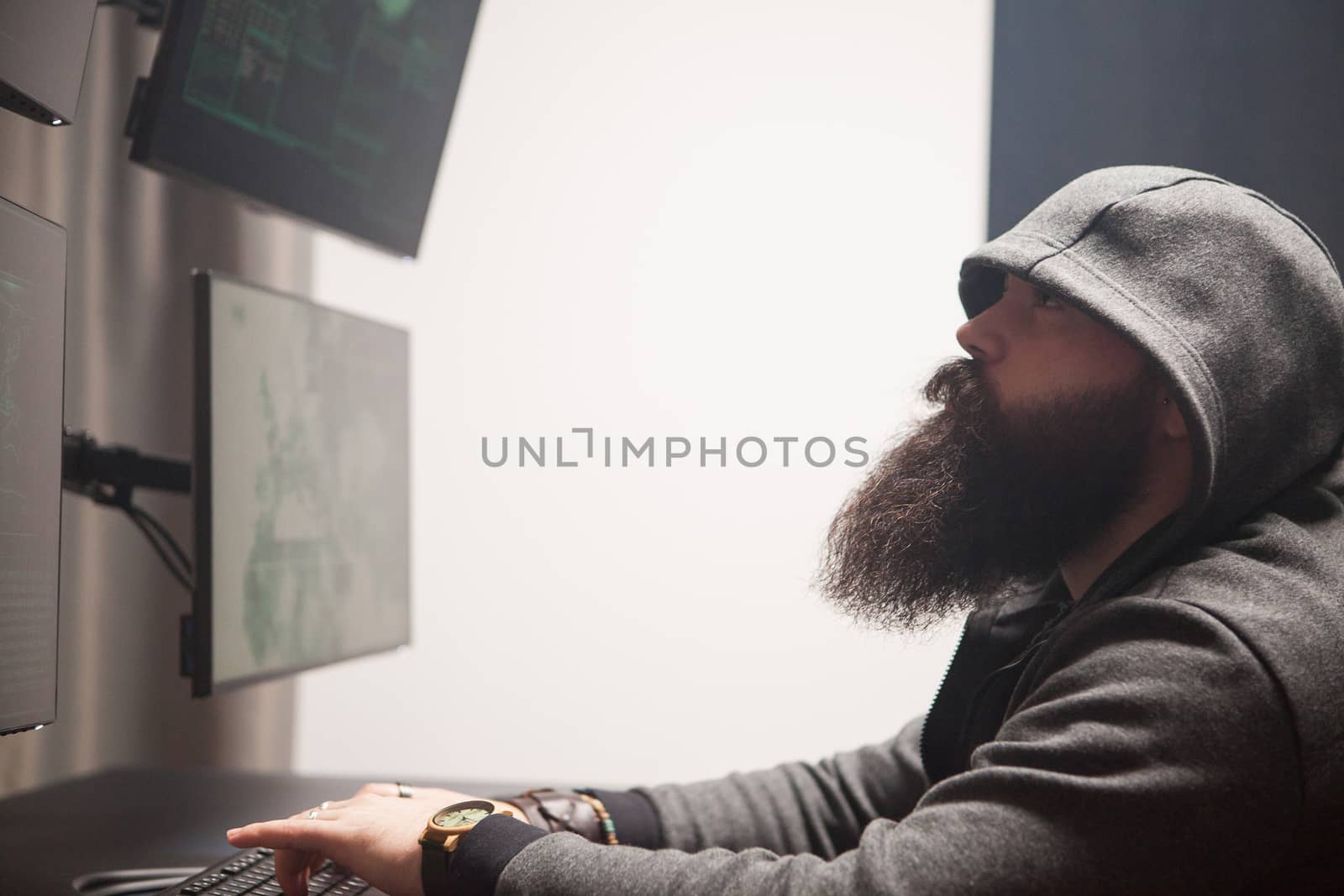Focused bearded hacker to destroy the system making a dangerous malware.