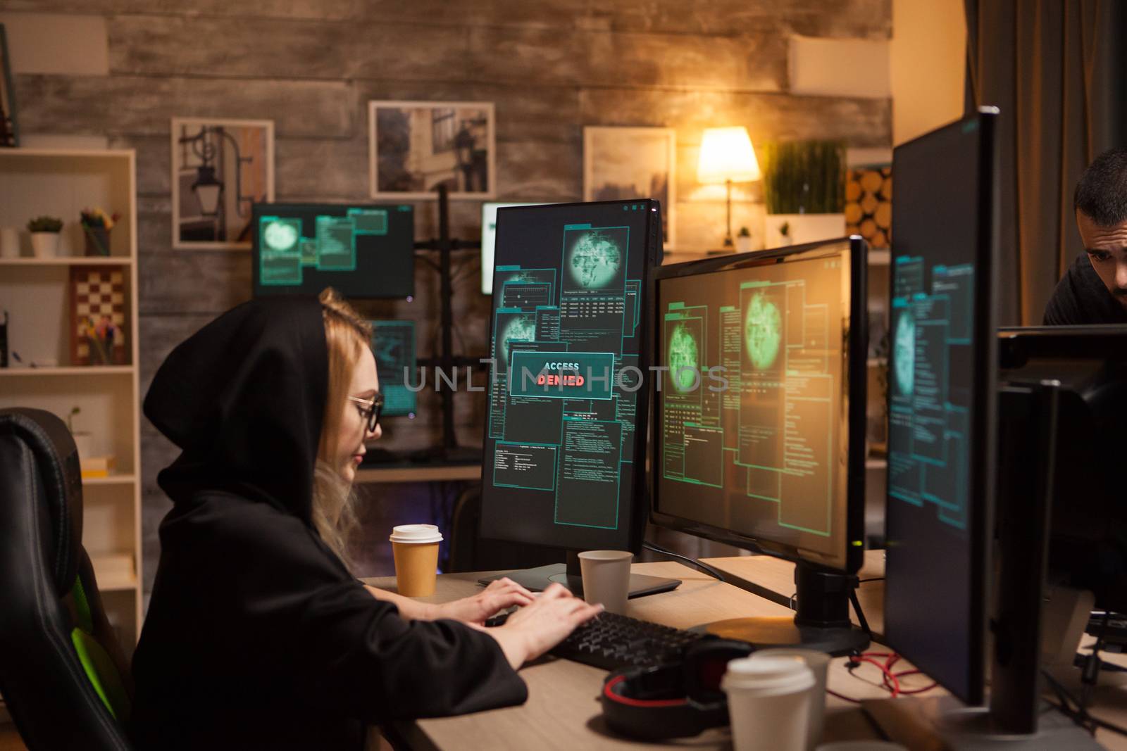 Side view of female hacker writing a dangerous malware using modern software.