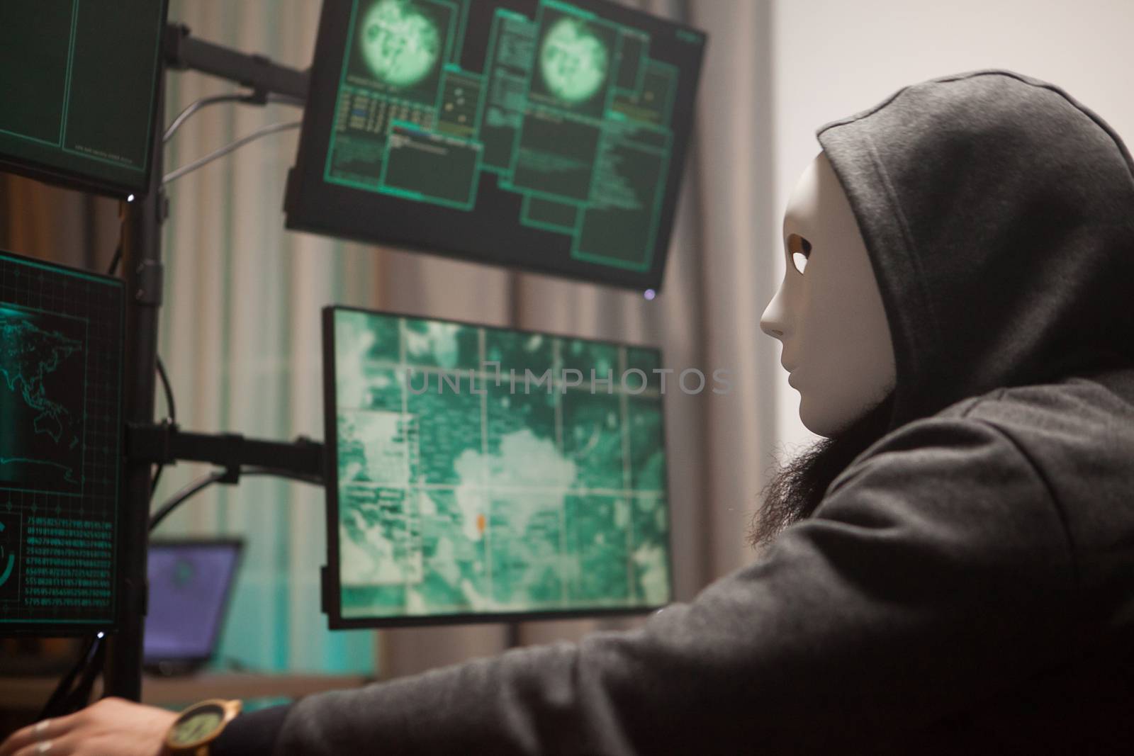 Wanted cyber terrorist wearing a mask to protect his identity while hacking gouvernements servers.